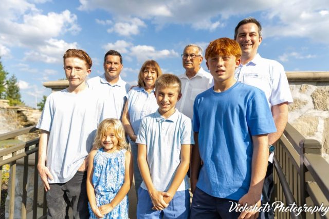 Whole Family by the Water Feature Extended family in coordinated blue gathered on a walkway beside a stone water feature