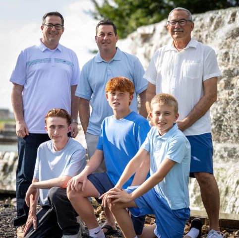 Fathers and Sons Together Three fathers with three boys in coordinated blue posed beside a stone water feature