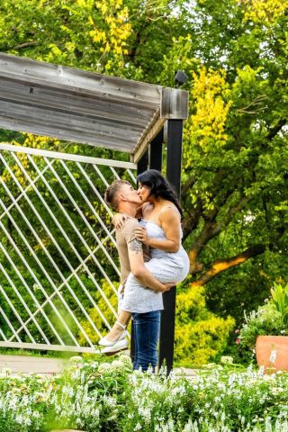 kiss beside the garden fountain Engaged couple kissing beside a garden fountain and pergola
