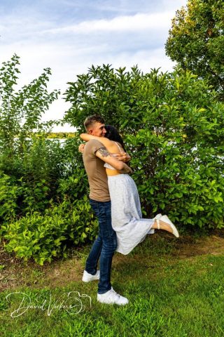lifted off her feet Man lifting and spinning his fiancee in the air outdoors