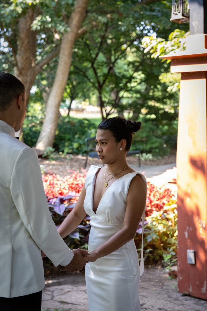 Wedding Photography Bride and groom holding hands during their wedding first look moment outdoors in Kansas City
