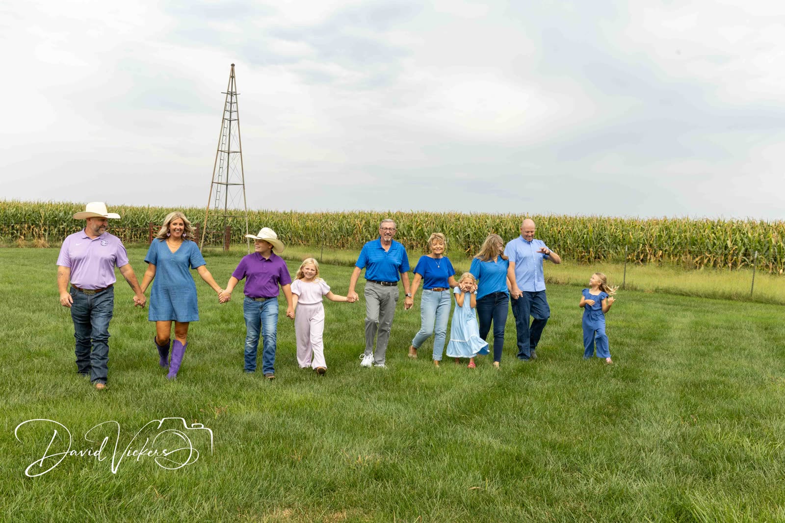 Family Photography Three generations of a family walking together hand in hand past a windmill at a Kansas City area family session