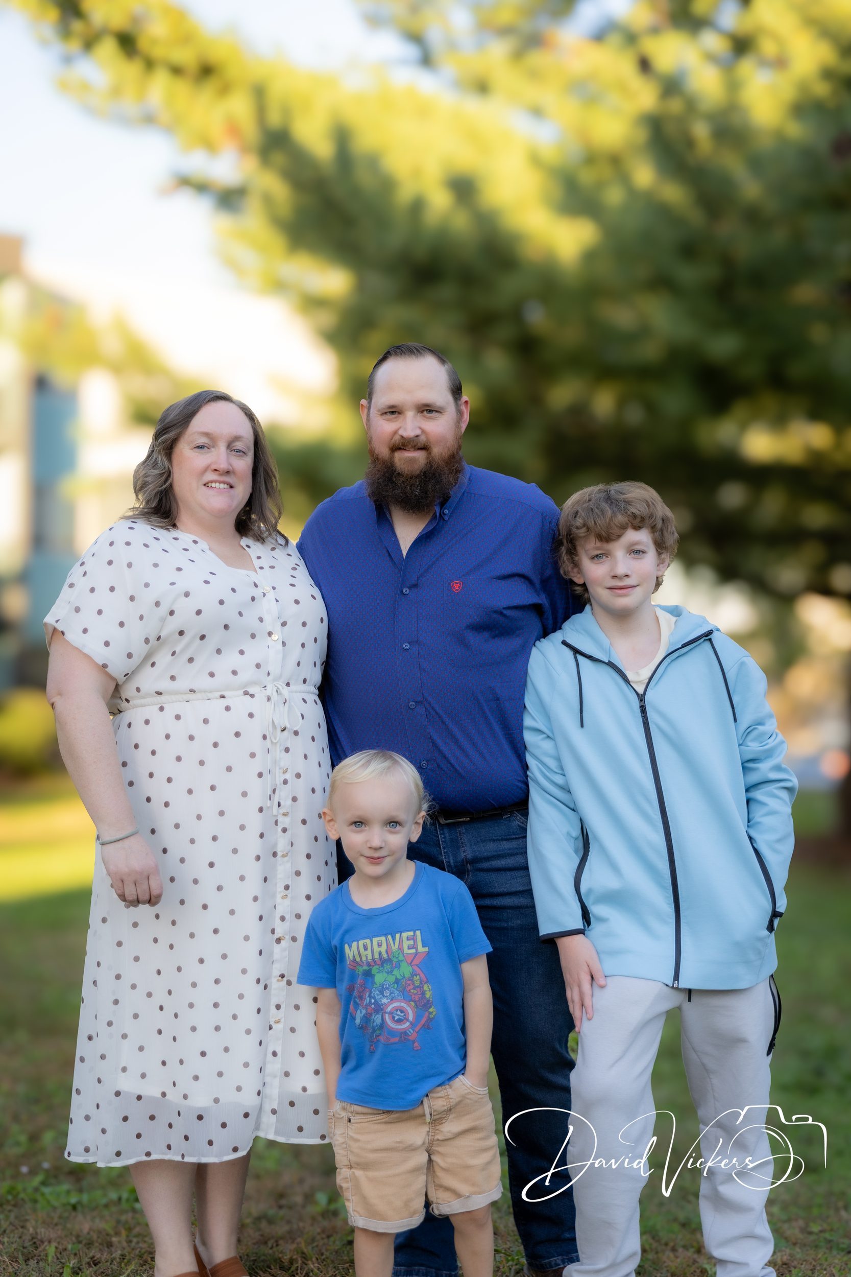 Lifestyle Family Photography in Kansas City: What to Expect A family of four standing together and facing the camera in a Kansas City park