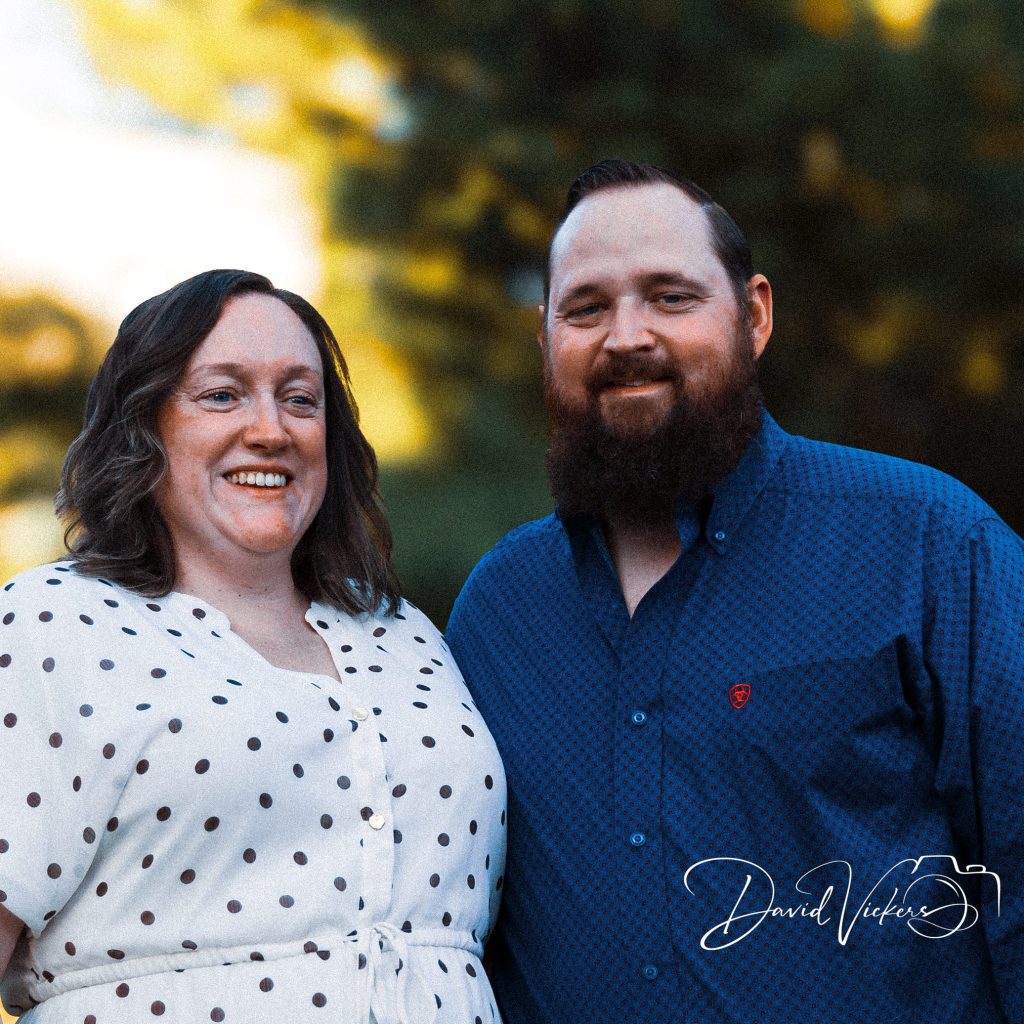 Close portrait of a smiling couple with warm sunset light behind them